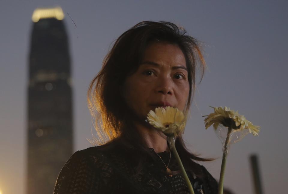 A woman attends a vigil for student Chow Tsz-Lok in Hong Kong, Saturday, Nov. 9, 2019. Chow Tsz-Lok, the Hong Kong university student who fell off a parking garage after police fired tear gas during clashes with anti-government protesters died Friday in a rare fatality in five months of unrest, fueling more outrage against authorities in the semi-autonomous Chinese territory. (AP Photo/Kin Cheung)