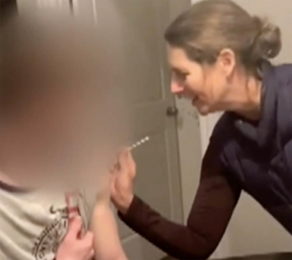 Laura Russo puts a needle in the arm of a 17-year-old boy.