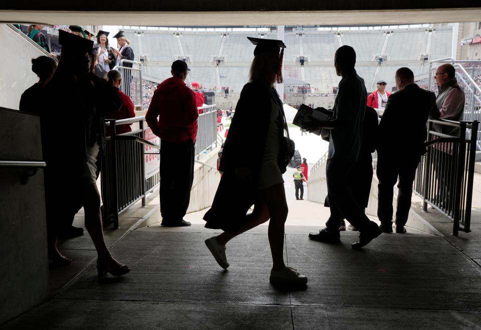 Graduates walk in the shade of the concourse during the Ohio State University's spring commencement on May 7 at Ohio Stadium.