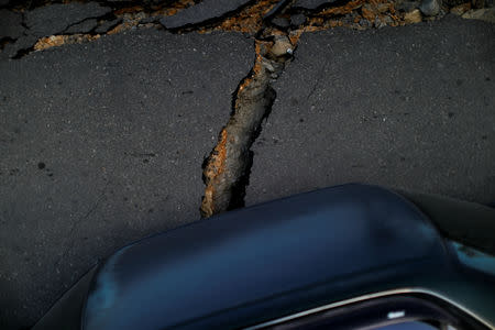 A car stands next to a road that was upended by the earthquake and ground liquefaction in Balaroa neighbourhood, in Palu, Central Sulawesi, Indonesia, October 10, 2018. REUTERS/Jorge Silva