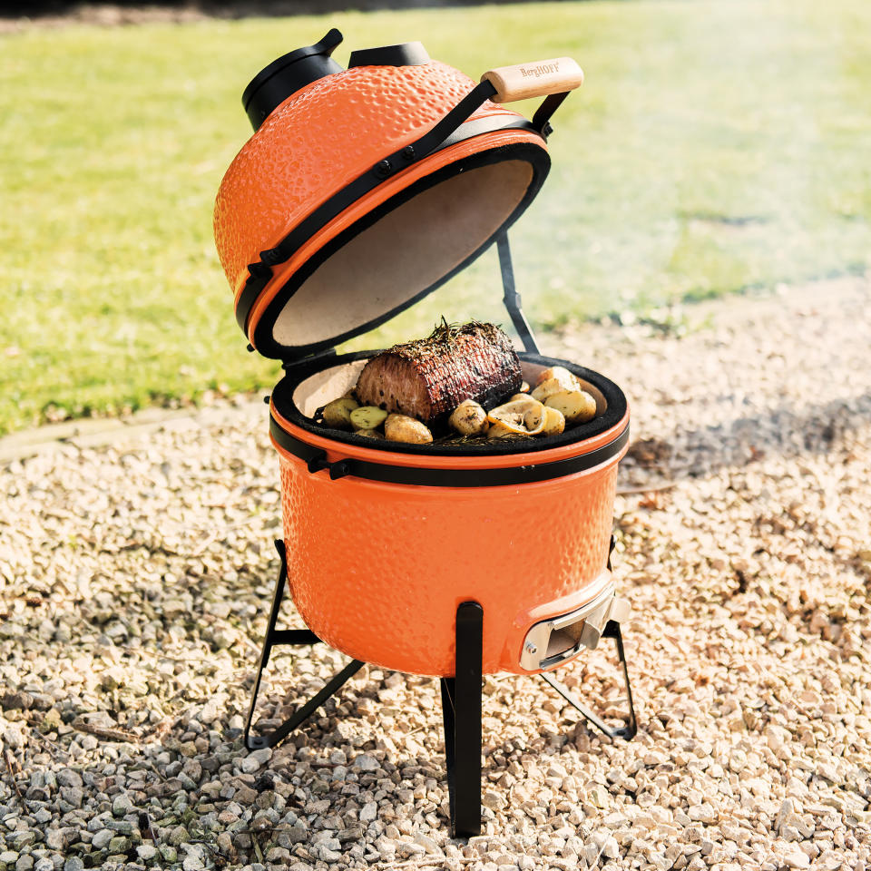 This photo provided by Riverbend Home shows the BergHOFF Small Ceramic BBQ Grill. This wood or charcoal grill is a good smaller size for urban patios, and can be used for searing, roasting, grilling or low-temperature smoking. The ceramic exterior is another grill offered in on-trend orange, as well as dark grey. (BergHOFF/Riverbend Home via AP)