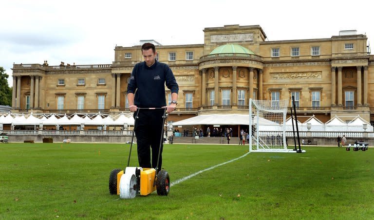 Karl Standley marks out a football pitch in the gardens of Buckingham Palace in London on Thursday. Preparations for the first football match to be staged at Buckingham Palace were stepped up when a pitch was marked out in the garden on Thursday