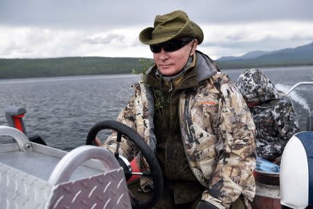 Russian President Vladimir Putin drives a boat during the hunting and fishing trip which took place on August 1-3 in the republic of Tyva in southern Siberia, Russia, in this photo released by the Kremlin on August 5, 2017. Sputnik/Alexei Nikolsky/Kremlin via REUTERS