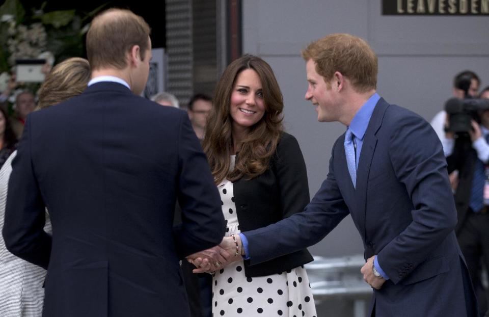 Britain's Kate the Duchess of Cambridge stands with her husband Prince William, left, and his brother Prince Harry, right, as they are greeted upon their arrival to attend the inauguration of "Warner Bros. Studios Leavesden" near Watford, approximately 18 miles north west of central London, Friday, April 26, 2013. As well as attending the inauguration Friday at the former World War II airfield site, the royals will undertake a tour of Warner Bros. "Studio Tour London - The Making of Harry Potter", where they will view props, costumes and models from the Harry Potter film series. (AP Photo/Matt Dunham)