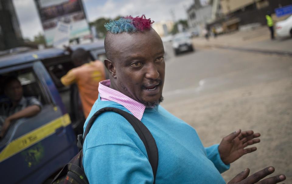 Prize-winning Kenyan author Binyavanga Wainaina talks to a cameraman as he walks down a street in Nairobi, Kenya Wednesday, Jan. 22, 2014. Wainaina, one of Africa's leading literary figures, spoke to The Associated Press on Wednesday to explain his decision to publicly declare his homosexuality in an online essay last weekend, in light of a wave of new legislation further criminalizing homosexuality in Nigeria and Uganda. (AP Photo/Ben Curtis)