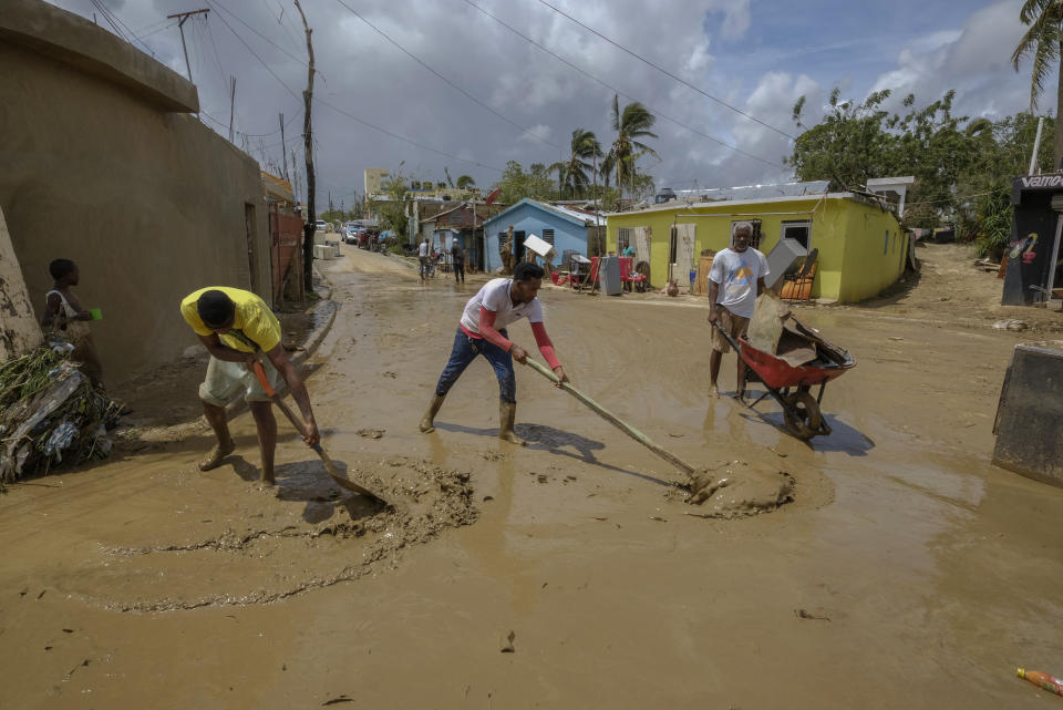 Locals clear mud brought by Hurricane Fiona in the Los Sotos neighborhood of Higuey, Dominican Republic, Tuesday, Sept. 20, 2022. (AP Photo/Ricardo Hernandez)
