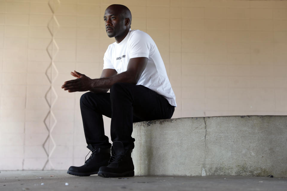 In this July 25, 2019, photo, filmmaker Chris Phillips poses for a photo in Ferguson, Mo. In 2014, Phillips lived in Canfield Apartments, a short distance from where Michael Brown was shot and killed by a Ferguson police officer. Phillips was a constant presence at the protests that followed, capturing the images of police clashing with demonstrators. Phillips soon realized the protests were about far more than Michael Brown and set out to document the movement. (AP Photo/Jeff Roberson)