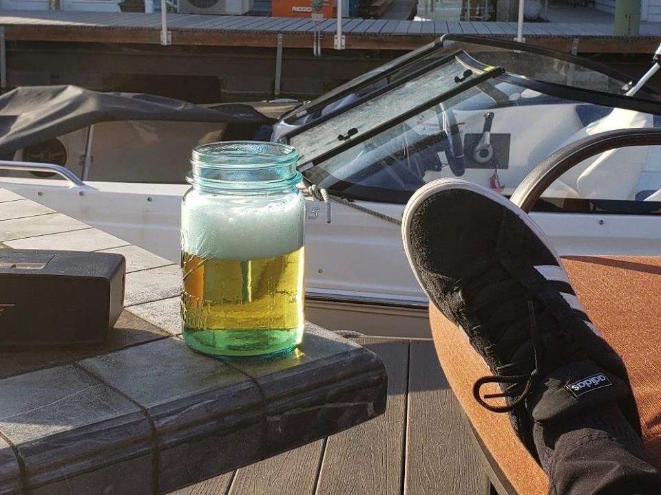 someone lounging on a doc with a glass of beer in the pacific northwest