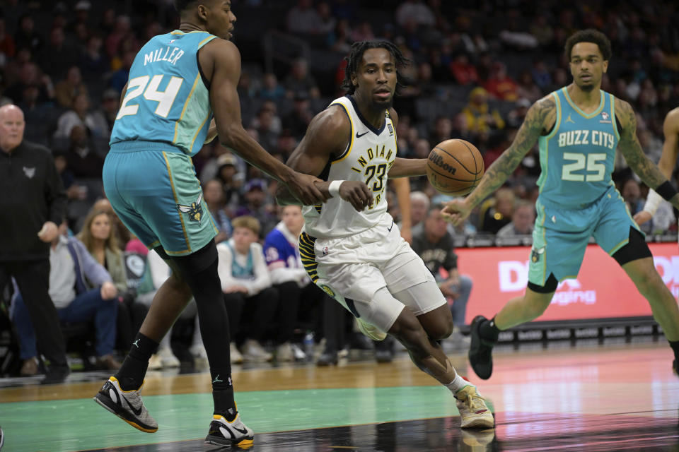 Indiana Pacers forward Aaron Nesmith (23) drives past Charlotte Hornets forward Brandon Miller (24) during the first half of an NBA basketball game, Sunday, Feb. 4, 2024, in Charlotte, N.C. (AP Photo/Matt Kelley)