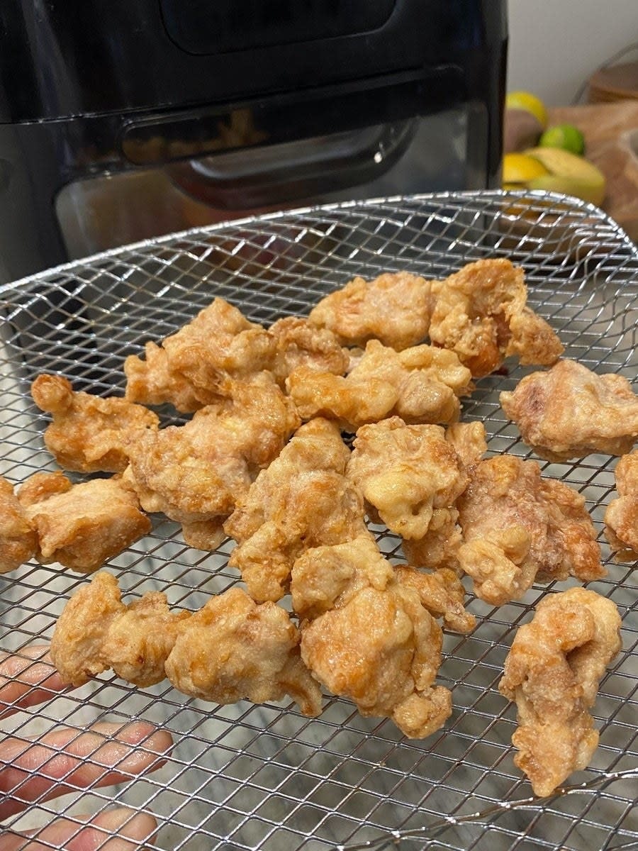 Mandarin orange chicken nuggets on an air fryer rack.