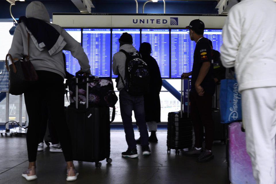 Travelers check information screens for flight status at O'Hare International Airport in Chicago, Thursday, Dec. 30, 2021. (AP Photo/Nam Y. Huh)