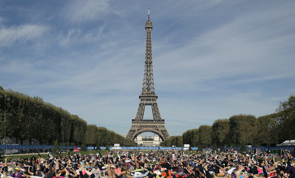 ARCHIVO - en esta fotografía de archivo del sábado 18 de septiembre de 2018, personas practican yoga frente a la torre Eiffel como parte del evento deportivo “La Parisienne” en París. (AP Foto/Christophe Ena, Archivo)