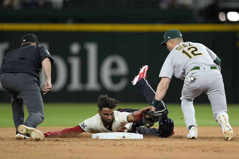 Umpire Tripp Gibson watches as Texas Rangers' Ezequiel Duran is tagged out trying to steal second by Oakland Athletics' Aledmys Diaz (12) during the fourth inning of a baseball game Friday, April 21, 2023, in Arlington, Texas. (AP Photo/Tony Gutierrez)