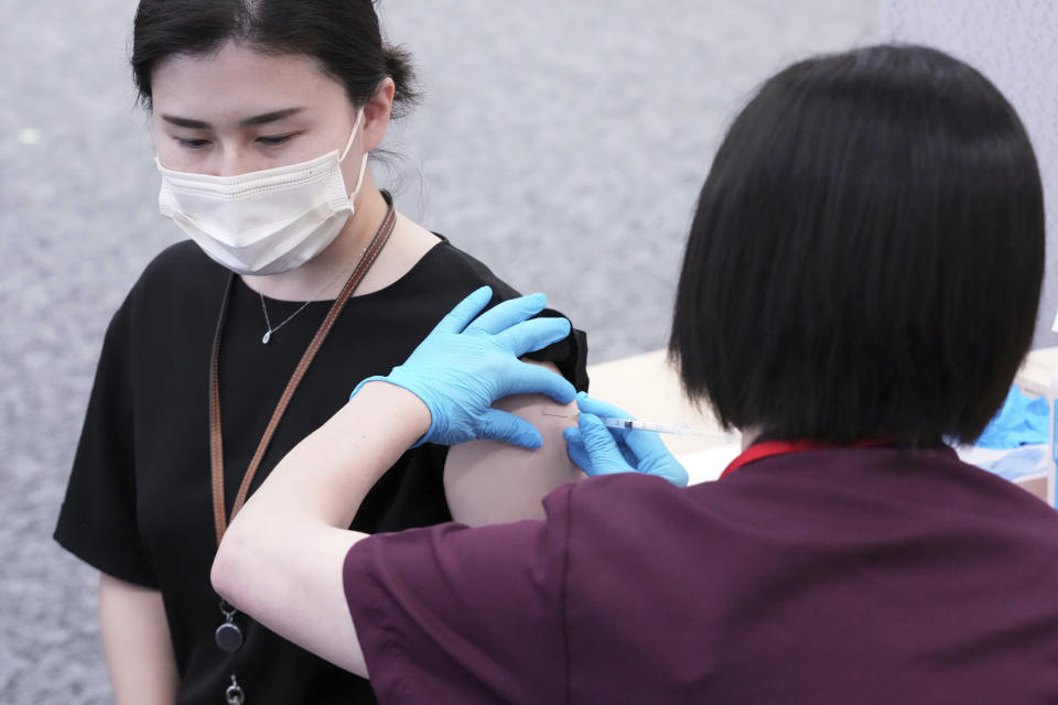 An employee of the beverage maker Suntory takes a Moderna COVID-19 vaccine shot at their office building as the company began its workplace vaccination Monday, June 21, 2021, in Tokyo. Thousands of Japanese companies began distributing COVID-19 vaccines to workers and their families Monday in an employer-led drive reaching more than 13 million people that aims to rev up the nation's slow vaccine rollout. (AP Photo/Eugene Hoshiko)