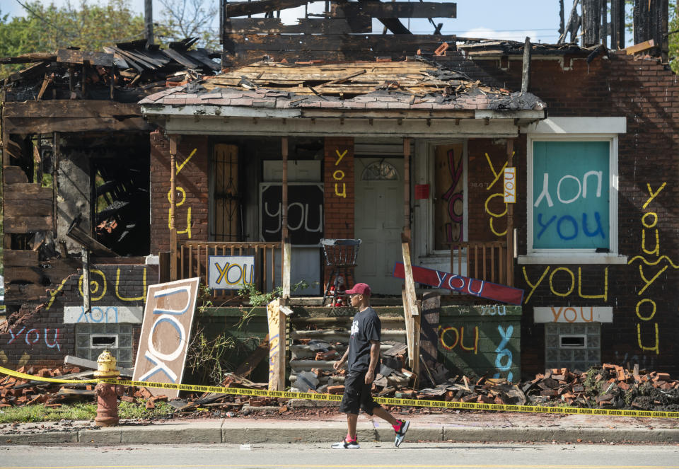 The "You" house at the Heidelberg Project in Detroit stands badly damaged after a fire early Monday, September 23, 2019. Arson investigators have a person of interest in custody and public safety officials are bringing out heavy equipment to knock down the house, part of the Heidelberg Project art installation. (David Guralnick/Detroit News via AP)