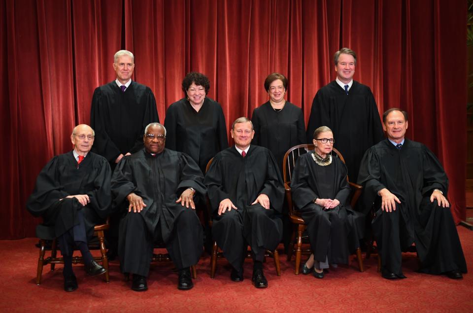The Supreme Court poses for its formal 2018 portrait, with Chief Justice John Roberts in the center seat and new Associate Justices Neil Gorsuch and Brett Kavanaugh standing on the left and right.