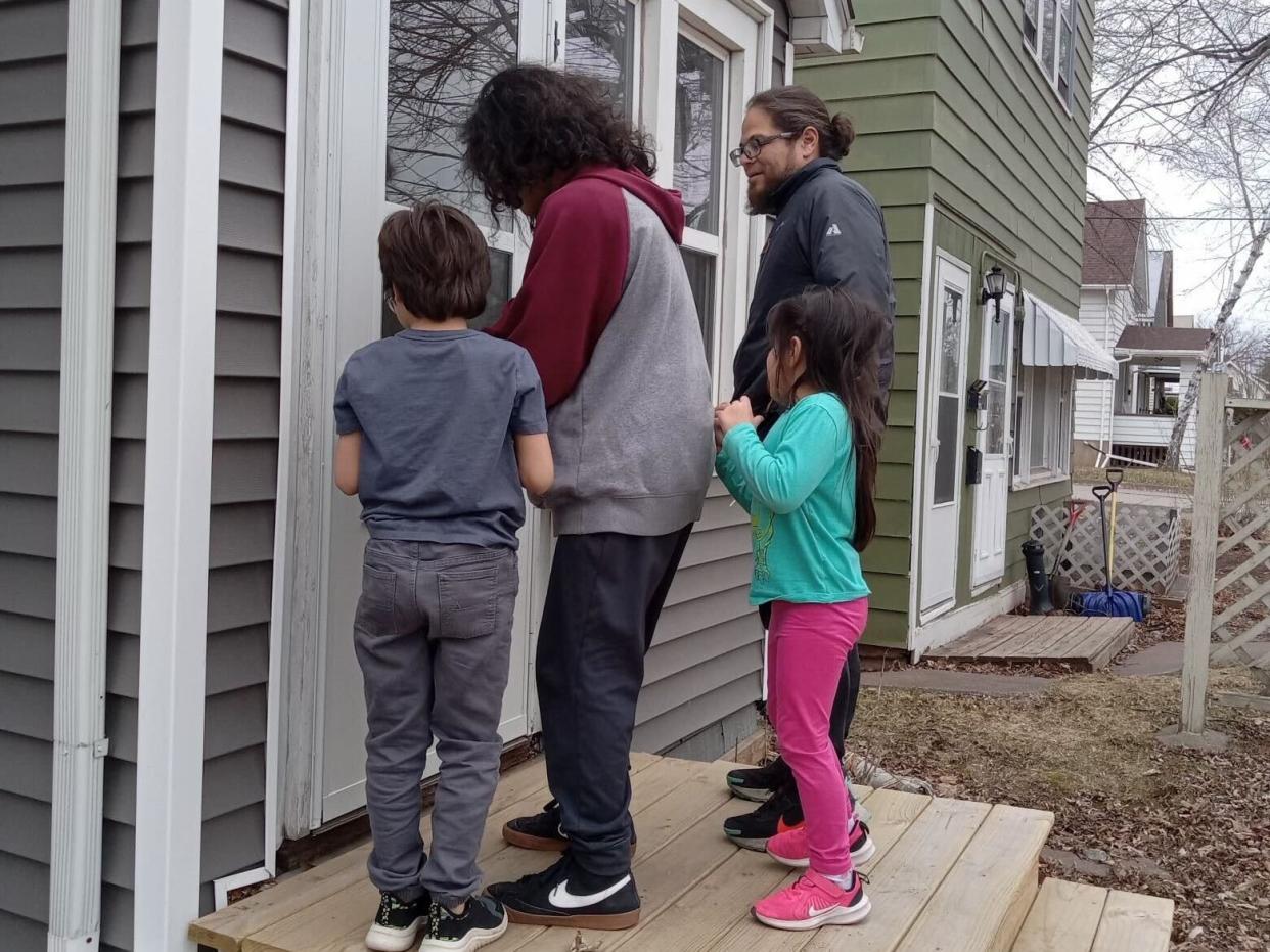 Melisa Gomez-Romo's husband and children at their front door.
