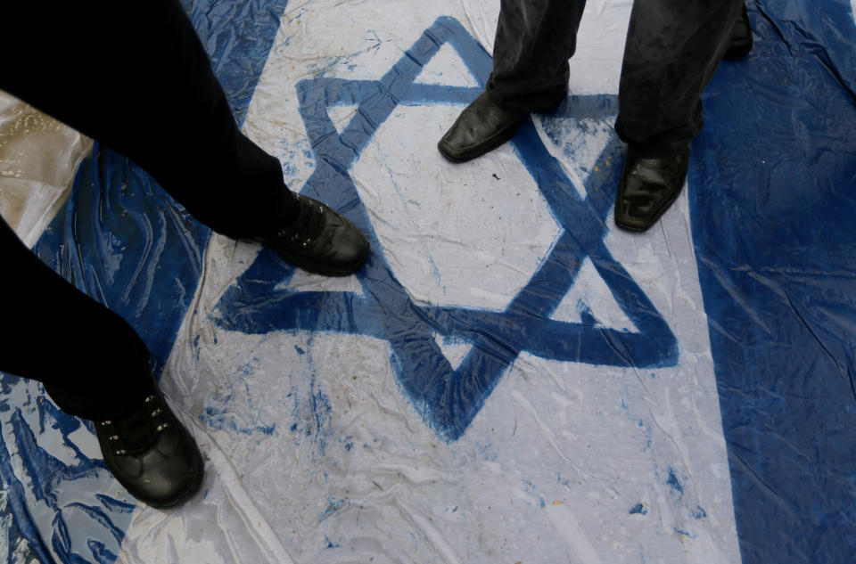 Palestinian supporters of the Islamic Jihad step on a representation of the Israeli flag as they demonstrate against resuming peace talks with Israel in Gaza City, Friday, Jan. 10, 2014. In recent weeks, U.S. Secretary of State John Kerry has stepped up involvement in the negotiations, shuttling between Abbas and Netanyahu to narrow considerable gaps between them on the outlines of a peace deal. (AP Photo/Hatem Moussa)