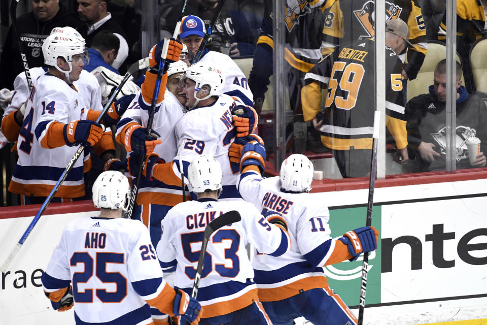 The New York Islanders celebrate a 4-3 overtime victory over the Pittsburgh Penguins during an NHL hockey game, Thursday, March 9, 2023, in Pittsburgh. (AP Photo/Philip G. Pavely)