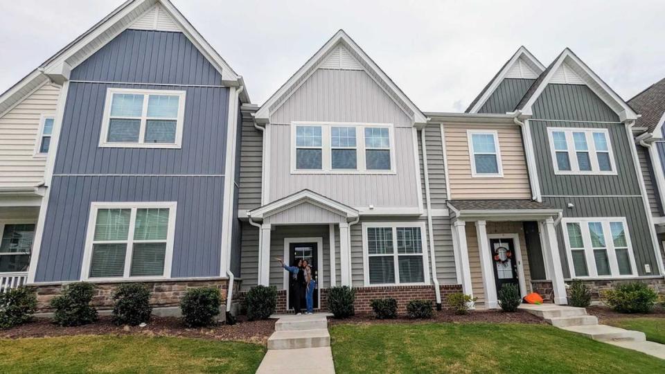 First-time homeowner Desirae Lewis is pictured with her daughter in front of her new townhouse in Brier Creek in Raleigh. She purchase the home last October using an alternative-financing plan.