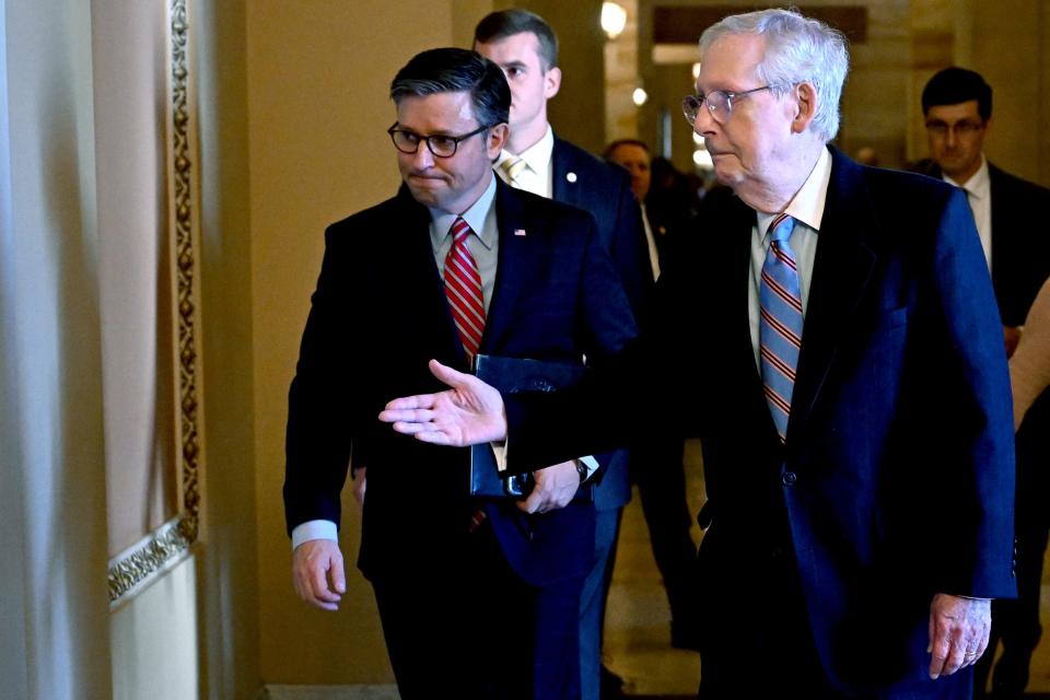 Mitch McConnell gestures to Mike Johnson