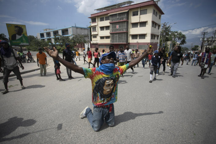 A demonstrator prays on his knees during a protest to demand the resignation of Prime Minister Ariel Henry in the Petion-Ville area of Port-au-Prince, Haiti, Monday, Oct. 3, 2022. (AP Photo/Odelyn Joseph)