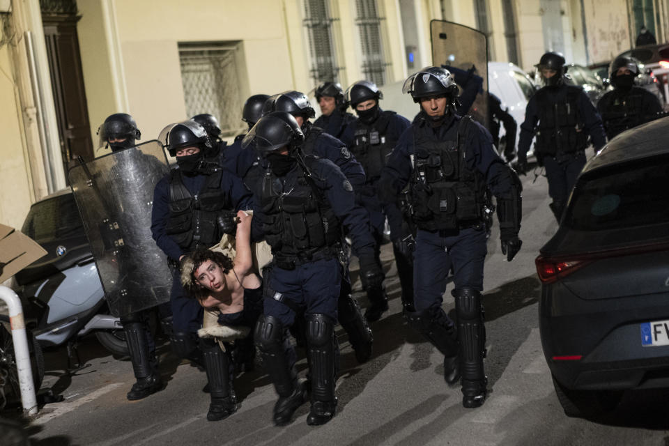 FILE - A carnival goer is arrested by riot police during Marseille's Carnaval de la Plaine in Marseille, southern France, Sunday, March 19, 2023. France's national police chief has said that law enforcement officers under investigation shouldn't be jailed like ordinary citizens, amid a walkout by numerous Marseille police over the detention of a colleague for his actions during nationwide riots. (AP Photo/Daniel Cole, File)