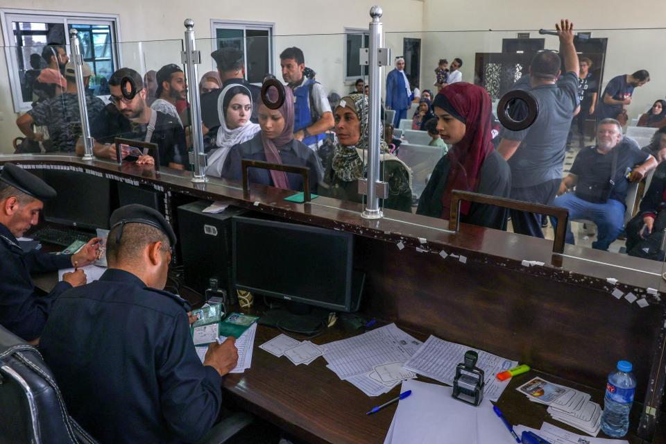 Egyptian border guards check the documents of people leaving Gaza (AFP via Getty Images)