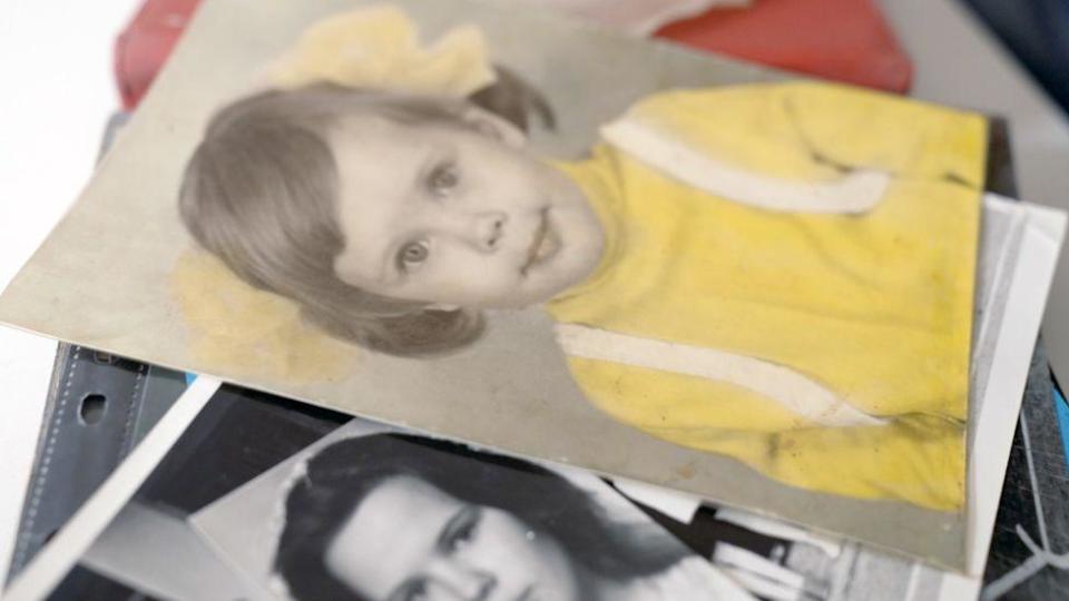 Photo of Francisco as a child, dressed as a girl, wearing a yellow blouse and hair in curls