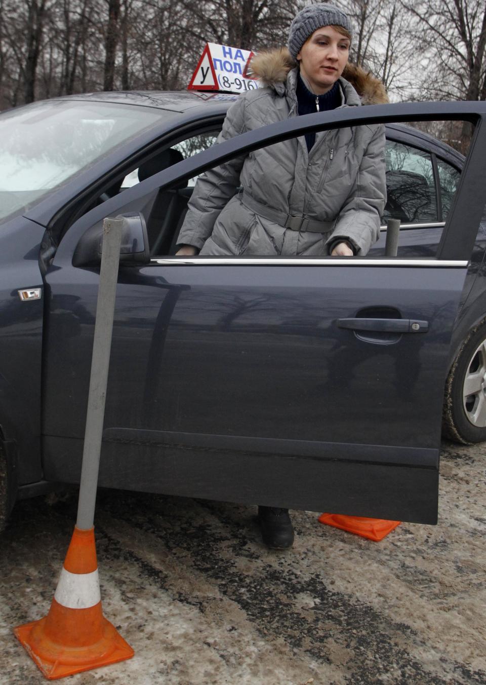 In this photo taken on Monday, Jan. 23, 2012, Natalya Veselova leaves her instructor's car at a driving training ground in the south-east of Moscow, Russia. For Veselova, applying for a driver's license has turned into a frustrating ordeal because she refuses to pay the customary bribe. (AP Photo/Mikhail Metzel)