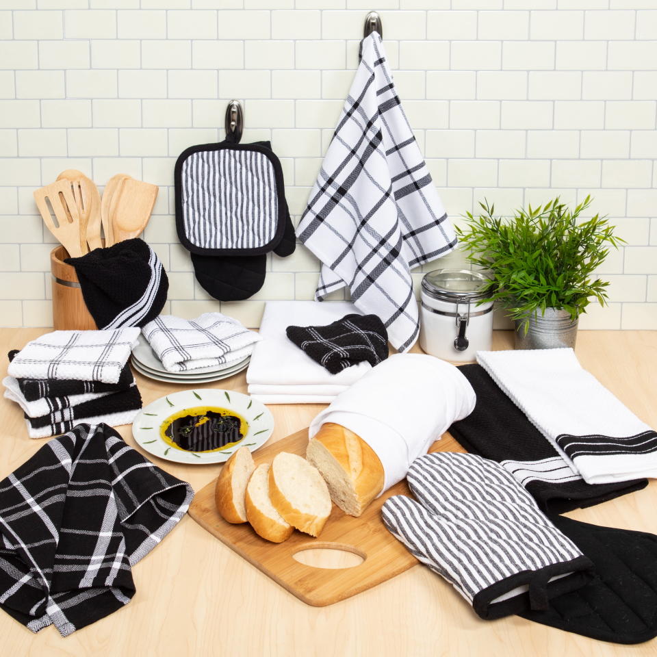 Various kitchen textiles and bread on a wooden cutting board displayed for shopping
