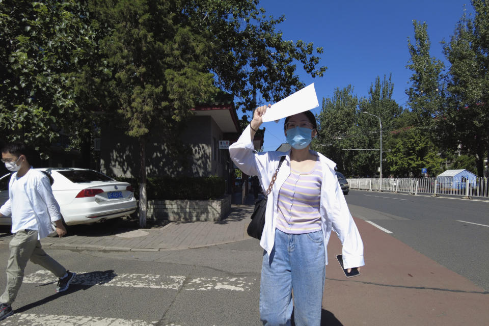 Recent college graduate Liu Qian walks along a street in Beijing, Thursday, July 7, 2022. Liu is one of 11 million new graduates desperate for work in a bleak job market as anti-virus controls force factories, restaurants and other employers to close. The survivors are cutting jobs and wages. (AP Photo/Olivia Zhang)