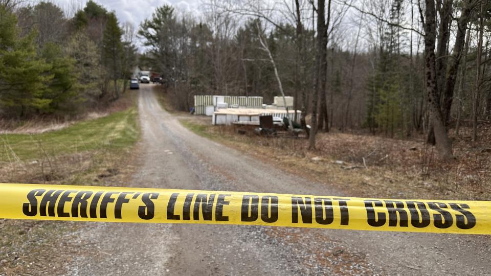 A sheriff's department caution tape is set up at the entrance of a crime scene in Bowdoin, Maine, on Wednesday, April 19, 2023. A Maine man who police say killed four people in a home and then shot three others randomly on a busy highway had been released days earlier from prison, a state official said Wednesday. (AP Photo/Rodrique Ngowi)