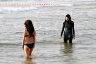 A Muslim woman wearing a Hijab stands next to a woman wearing a bikini in the Mediterranean Sea at a beach in Tel Aviv, Israel August 30, 2016. REUTERS/Baz Ratner