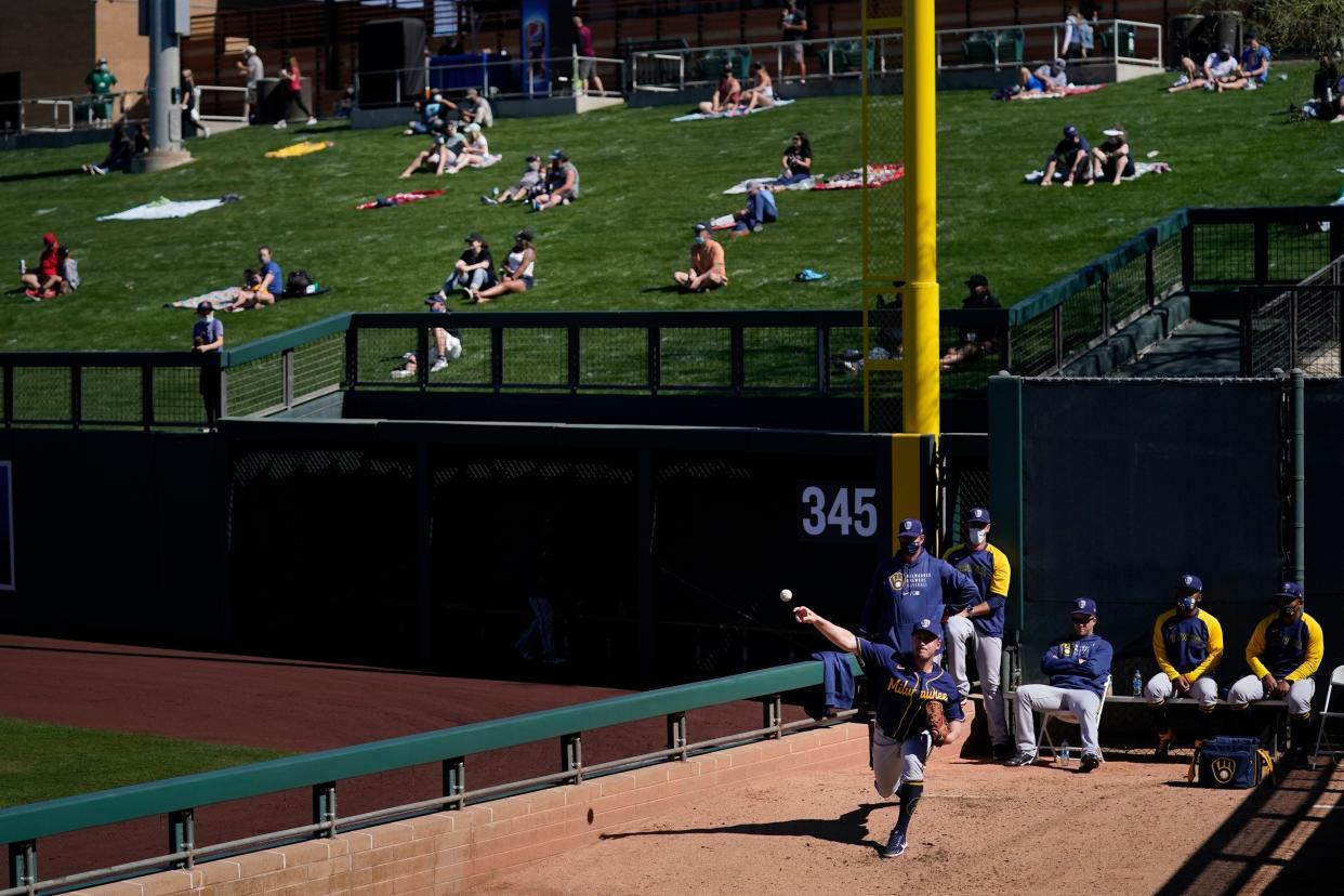 Milwaukee Brewers pitcher Jordan Zimmermann, bottom right, warms up in the bullpen as socially distanced fans watch the Brewers' spring baseball game with the Arizona Diamondbacks in Scottsdale, Ariz., Monday, March 1, 2021. (AP Photo/Jae C. Hong)