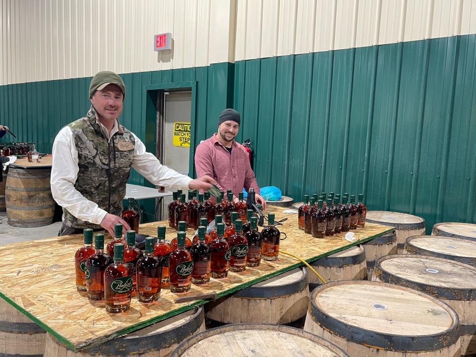 At left, Max Merrill, of Berlin, president of Ponfeigh Distillery, and Alex Merrill, from Virginia, attach embroidered patches onto bottles of Ponfeigh Westsylvania Rye Whiskey.