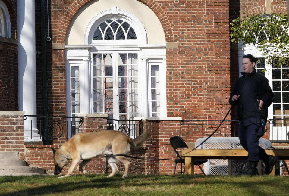 A Virginia Department of Corrections canine team searches the scene near an overnight shooting that occurred at the University of Virginia, Monday, Nov. 14, 2022, in Charlottesville. Va. (AP Photo/Steve Helber)