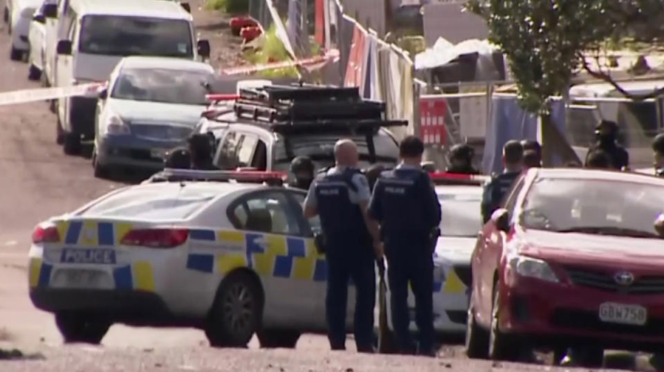 This image made from a video, shows armed police at the scene of a shooting incident following a routine traffic stop in Auckland, New Zealand, Friday, June 19, 2020. New Zealand police say a few officers have been shot and seriously injured and a suspect is on the run. (TV New Zealand via AP)