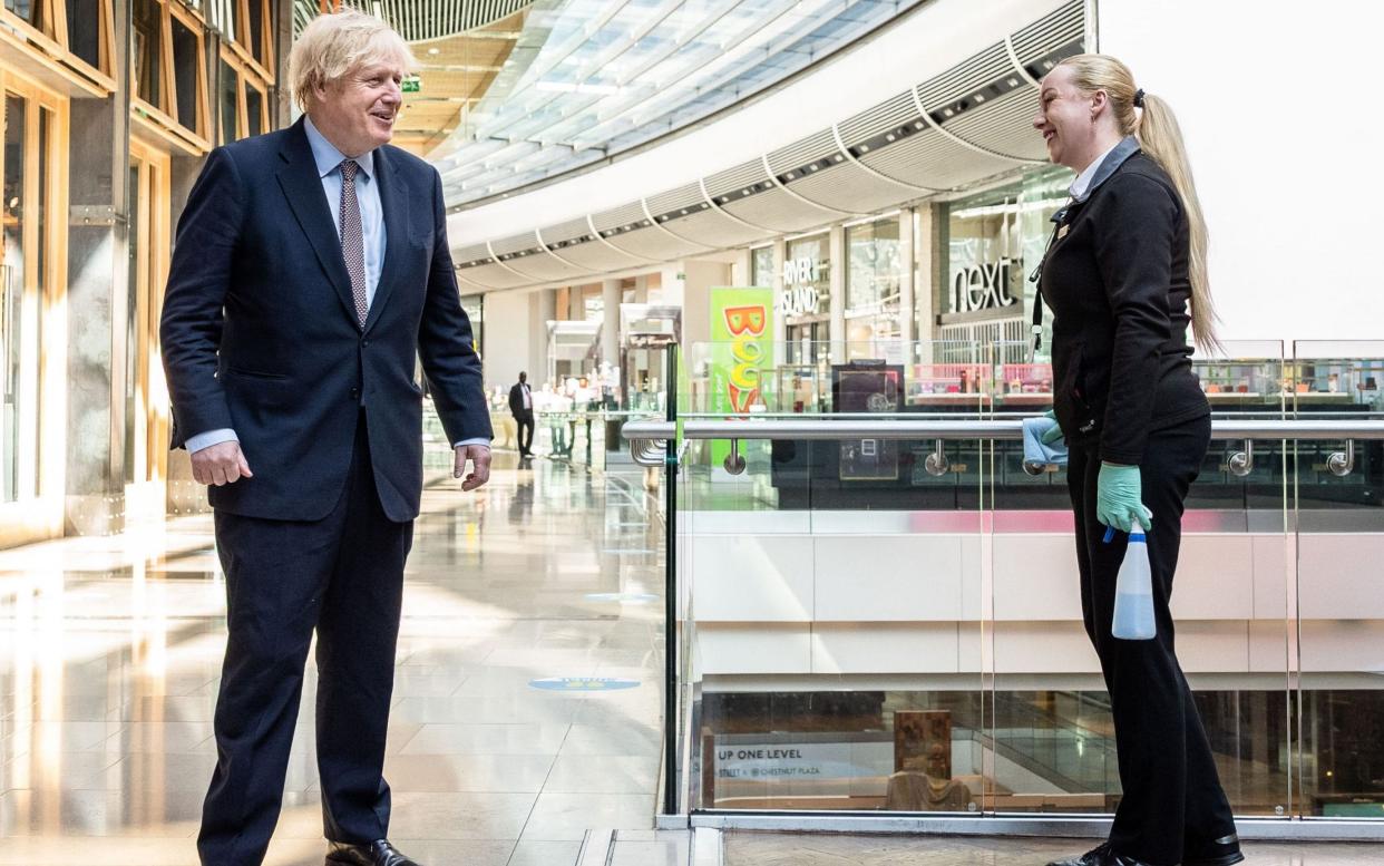 Britain's Prime Minister Boris Johnson speaks to a worker at Westfield shopping centre in east London  - AFP