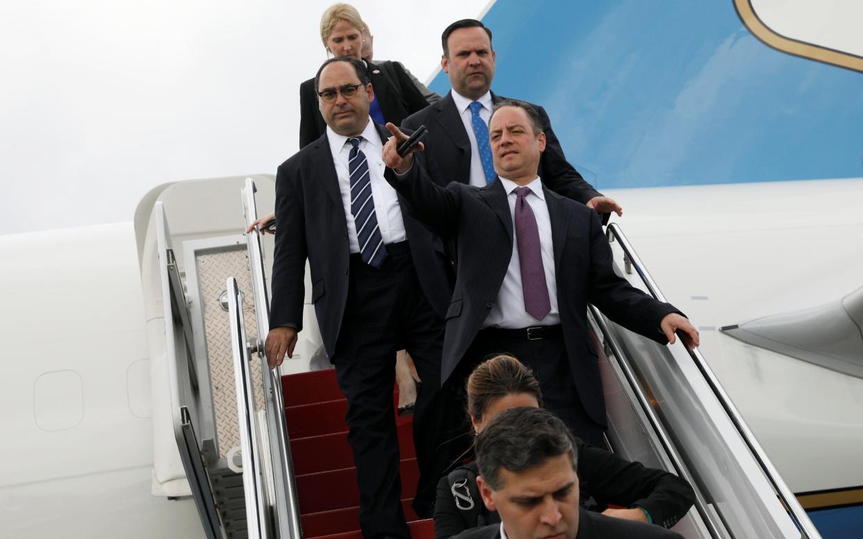 Reince Priebus (pointing) with other staff members disembarking from Air Force One on Friday - Reuters