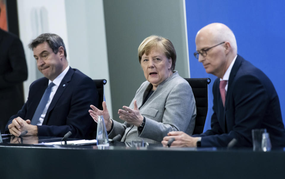 Markus Soder, Prime Minister of Bavaria, left, Germany's Chancellor Angela Merkel, center, and Peter Tschentscher, First Mayor of Hamburg, speak at a press conference in the Federal Chancellery, Berlin, Wednesday April 15, 2020. After much-anticipated talks Wednesday with Germany’s 16 state governors, Chancellor Angela Merkel set out a plan for the first steps of a cautious restart of public life — following countries including neighboring Austria and Denmark in launching a slow loosening of restrictions. (Bernd von Jutrczenka/Pool via AP)