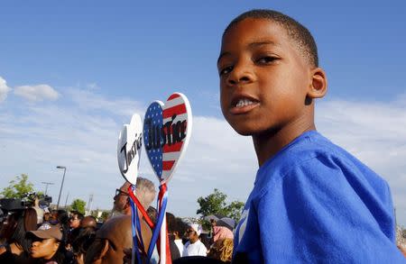 Aarington Traylor holds signs calling for justice during a protest against what demonstrators call police brutality in McKinney, Texas June 8, 2015. REUTERS/Mike Stone