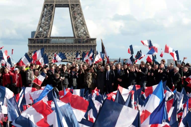 French presidential election candidate for the right-wing Les Republicains party Francois Fillon (C), flanked by his wife Penelope Fillon and his daughter Marie Fillon, acknowledges the crowd as he stands on stage near the Eiffel Tower