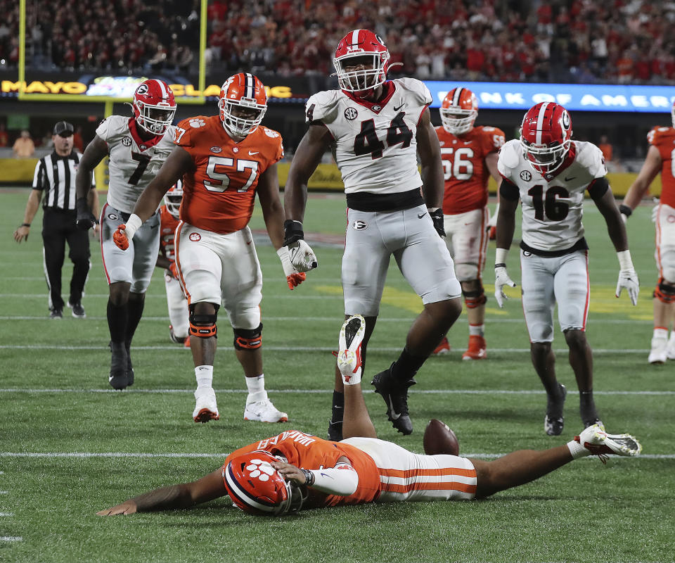 Clemson quarterback D.J. Uiagalelei is knocked to the turf by Georgia defender Travon Walker on a broken play during the second half of an NCAA college football game Saturday, Sept. 4, 2021, in Charlotte, N.C. (Curtis Compton/Atlanta Journal-Constitution via AP)
