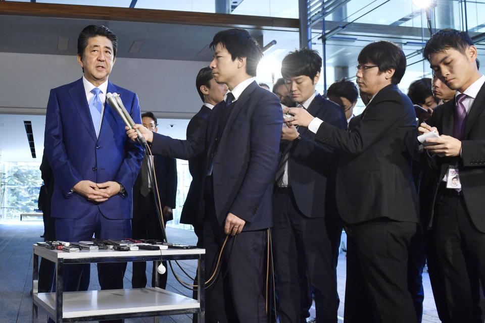 Japan's Prime Minister Shinzo Abe, left, speaks to media at his office Wednesday, Nov. 20, 2019, in Tokyo. Abe has made history by becoming Japan’s longest-serving political leader, though he hasn’t achieved his biggest goal of revising the nation’s pacifist constitution. (Kyodo News via AP)