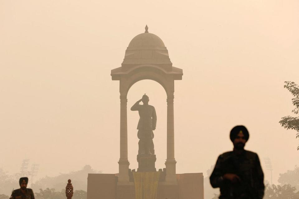 Soldiers stand guard during heavy smog under the statue of Subhas Chandra Bose behind the India Gate (Reuters)