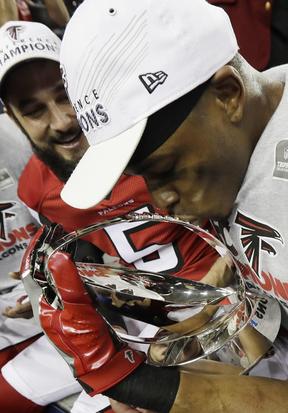 Atlanta Falcons' Deji Olatoye kisses the George Halas Trophy after the NFL football NFC championship game against the Green Bay Packers, Sunday, Jan. 22, 2017, in Atlanta. The Falcons won 44-21 to advance to Super Bowl LI. (AP Photo/David J. Phillip)