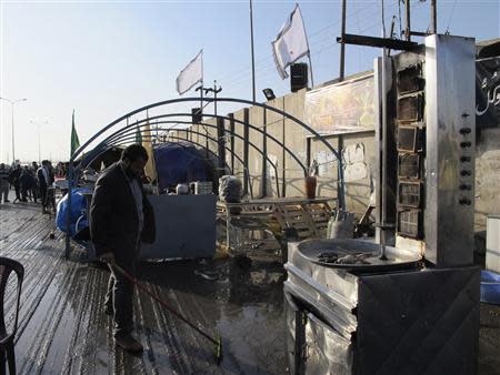 A man sweeps the floor at the site of a bomb attack in Baghdad's Doura District, December 19, 2013. REUTERS/Ahmed Malik