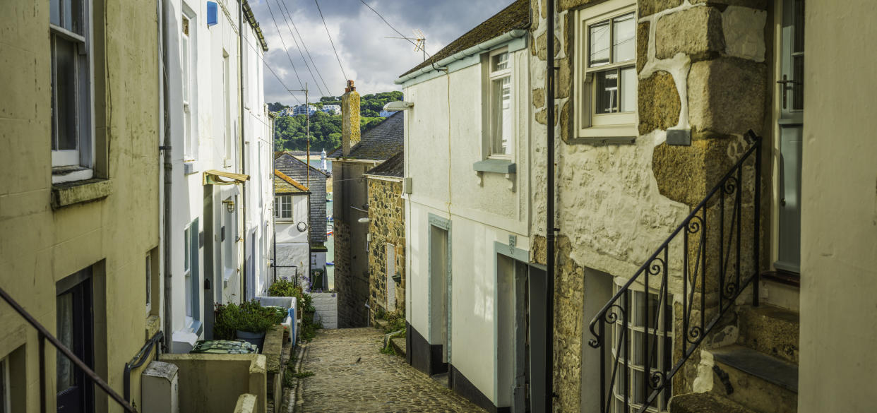 The narrow cobbled streets of St Ives are lined with honey hued houses. (Getty Images)