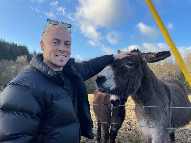 Patrick O'Connor petting a donkey